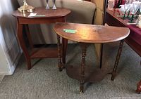 Two side tables shown together, the wood demilune table in front with visible surface wear and the faux wood table behind it.