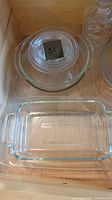 Photo showing nested clear glass mixing bowls, a clear round salad plate, and a rectangular clear glass cake or bread pan.