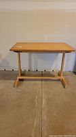 Front view of solid wood work table showing sturdy rectangular top and support base