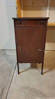 Front view of vintage wooden record cabinet with drawer and door closed