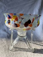 Side view of the Czech spatter glass bowl showing colorful spots on clear glass and tripod base.