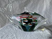 Clear Murano glass fish sculpture full side view showing contour and embedded fish inside.