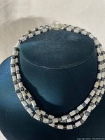 Full front view of vintage choker necklace on black bust showing twisted metal and black square elements