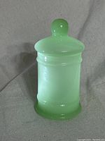 Front view of opaque jadeite glass jar with fitted lid in place