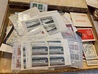 Top view of Canadian postage stamps, mainly folios and booklet panes, including visible $50 denomination and seascape design