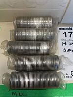 Photo showing five rolls of Canadian millennium quarters wrapped in clear plastic.