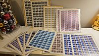Photo showing 15 Canadian stamp sheets with multiple stamp designs laid out including some behind others and visible detailed colorful prints.