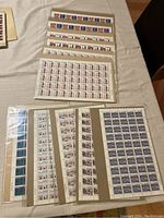 Multiple sealed sheets of Canada Christmas stamps from 1974 and 1975 displayed on a table