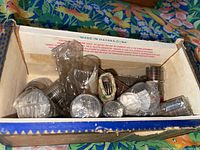 Box holding multiple rolls of US coins, mostly quarters in coin wrappers.