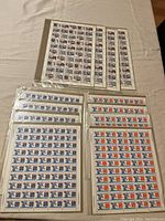 Overview of multiple sealed sheets of stamps in plastic protective sleeves, showing the full lot of eight sheets.