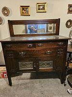 Front view of antique oak sideboard with beveled mirror and leaded glass doors
