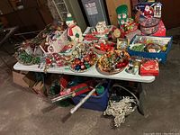 Table top display of assorted Christmas decorations showing blow mold snowman, decorative bowls of ornaments, gift tins, various small items