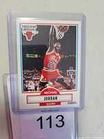Front of the 1990 Fleer #26 Michael Jordan basketball card showing player in action dunking in Chicago Bulls red uniform.