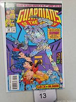 Front cover photo showing the comic book Guardians of the Galaxy #39 with chrome embossed artwork of a robot fighting a woman with claws in vibrant colors.