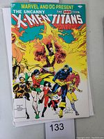 Front cover of the comic book Marvel and DC present The Uncanny X-Men and The New Teen Titans #1 showing various superhero characters.