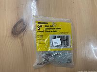 Front view of a sealed Stanley 3-inch chain bolt lock in yellow packaging showing label and barcode.