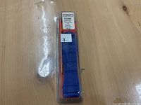 Blue Forney chainsaw file handle in original clear plastic clamshell packaging, labeled with product info including size 7/32 inch.