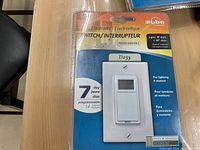 Front view of the packaged Aube electronic switch showing the white switch, digital programming screen and retail packaging.