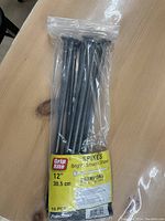 Plastic bag containing 10 Grip Rite 12 inch bright smooth shank spikes with label visible.