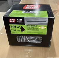 Box of Grip Rite finish nails, clearly showing label with product specifications including size 10d, 3 inches (7.62 cm), 1.5 kg weight, smooth shank, hot dipped galvanized
