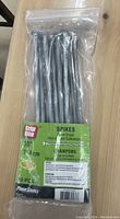 Photo of a sealed clear plastic bag containing 10 Grip Rite spiral shank spikes measuring 10 inch (24.4 cm) hot-dipped galvanized.