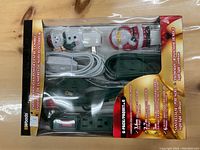 Photo of the indoor holiday power centre combo showing power strips, cords, and themed plug covers in original packaging.