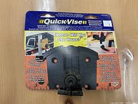 Photo of Quick Vise branded portable workbench accessory still in packaging, showing product front and instructions.