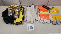 Multiple pairs of large new mixed duty work gloves in various colors and materials, some with tags intact