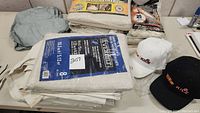 Stack of commercial drop cloths, rags, and packaged booties on table