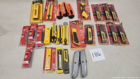 Full lot image showing multiple utility knives, cutters, and replacement blade packs arranged on a surface.