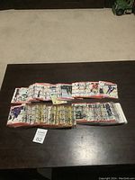 Multiple stacks of 1990 Score hockey cards laid out on a dark table surface, showing the full collection and card fronts and backs.