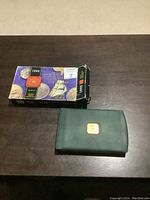 Original box and green presentation folder with gold emblem.