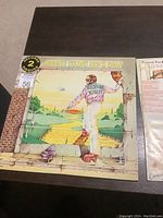 Front cover of Elton John Goodbye Yellow Brick Road double LP album showing colorful illustration and title