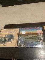 Two Grateful Dead vinyl albums on a dark table, showing front covers of Workingman's Dead on the left and Dead Set on the right.