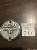 Front view of round Harley Davidson tank plate with text 'LIVE TO RIDE' and logo, showing textured metal surface and two mounting holes.