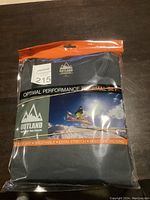 Photo of packaged Outland thermal underwear set showing front label with brand, size Large, and performance features.