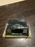 Front view of sealed diecast model in original packaging showing vehicle on display base with label.