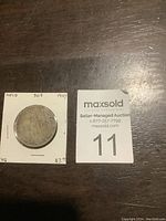 Front of 1907 Newfoundland 50 cent coin mounted on a card with handwritten details and price.