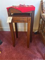 Full view of the two wooden nesting end tables stacked together, showing their design and condition.