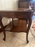 Side view showing overall shape, design, and lower shelf of the wooden side table.