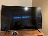 Full view of Samsung TV set atop oak cabinet