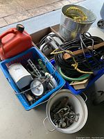 Photo showing multiple containers with assorted hardware, extension cord, and red plastic jerry can