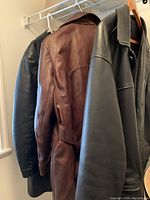 Side view of the three leather jackets hanging together showing colors and styles