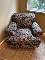 Front and angled view of floral accent chair showing full upholstery and arm design