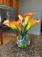 Side view of the faux calla lily bouquet in round glass vase on kitchen counter.