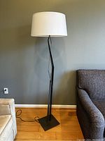 Full view of floor lamp against wall showing overall height and shape