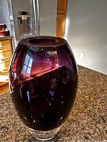 Angled side view of amethyst purple art glass vase with Krosno Poland label on side.