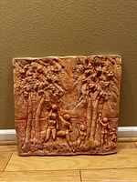 Front view of terracotta carving showing scene of five figures among palm trees.