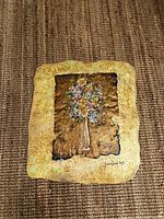 Full view of floral shiny slab art on fabric surface.