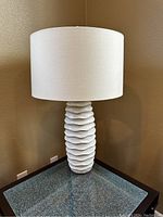 Full view of white ceramic bedside table lamp showing texture and shape